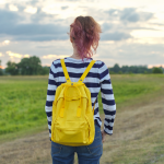 May contain person with yellow backpack and striped shirt outdoors.